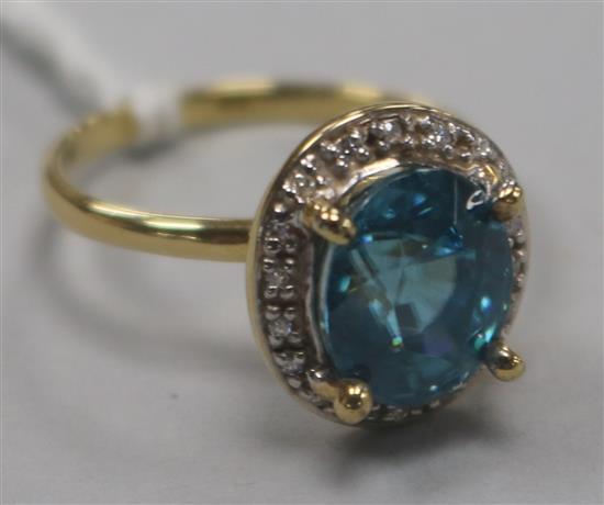 A 9ct gold, blue zircon and diamond set oval cluster ring, size N.